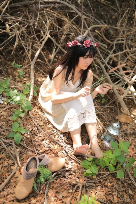 Rapariga asiática bonita a posar com o seu bonito vestido branco numa bela natureza