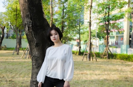 Sød asiatisk pige poserer i en park, før hendes store bryster bliver afsløret af en fyr