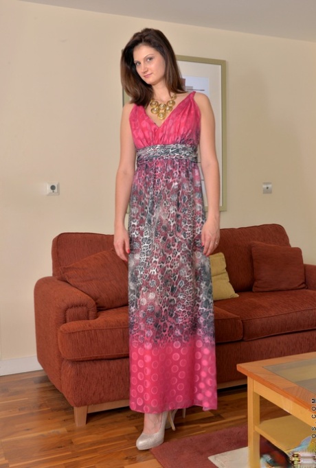 Rumänska MILF Eva Johnson tar av sig sin långa klänning och trosor för att sprida sin muff