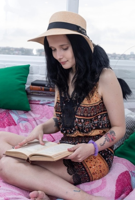 Сексуальная брюнетка-любительница раздевается и играет со своей волосатой киской во время чтения книги